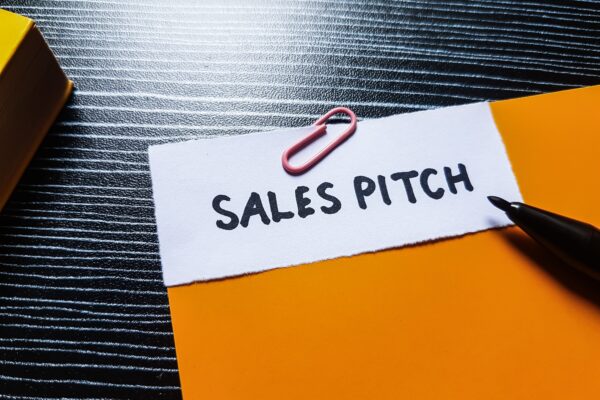 A paper with the words ‘Sales Pitch’ pinned against a colored sheet.